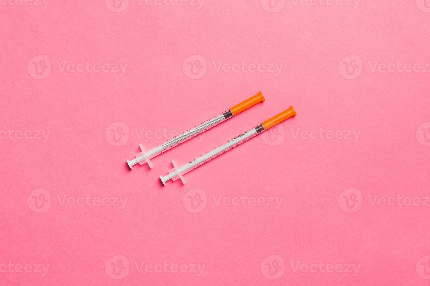 Top view of two insulin syringe at colorful background with copy space. High level of glucose concept photo