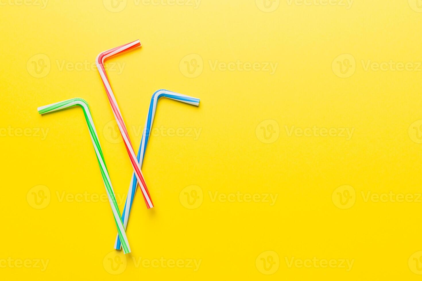 Drinking straws for party on Colored background. Top view of colorful plastic disposable straws for summer cocktails. different straws for juice with copy space photo