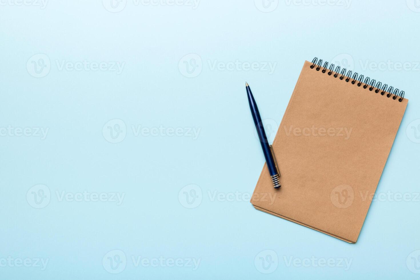 school brown notebook on a colored background, spiral craft notepad on a table Top view photo