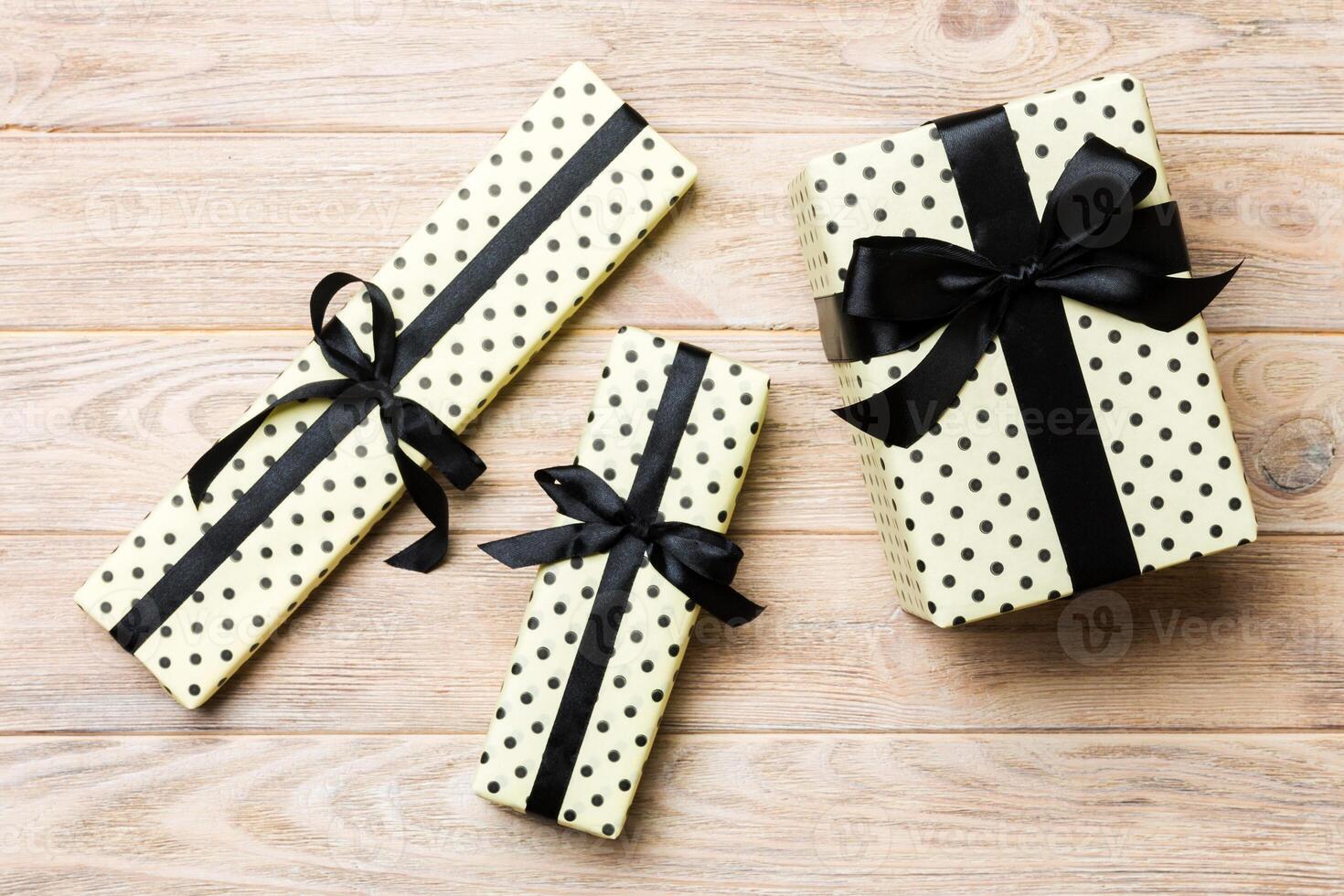 Top view of christmas or other holiday handmade present box package, flat lay yellow wooden background with copy space. new year gift box photo