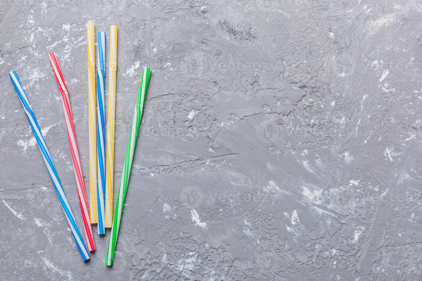 Drinking straws for party on Colored background. Top view of colorful plastic disposable straws for summer cocktails. different straws for juice with copy space photo
