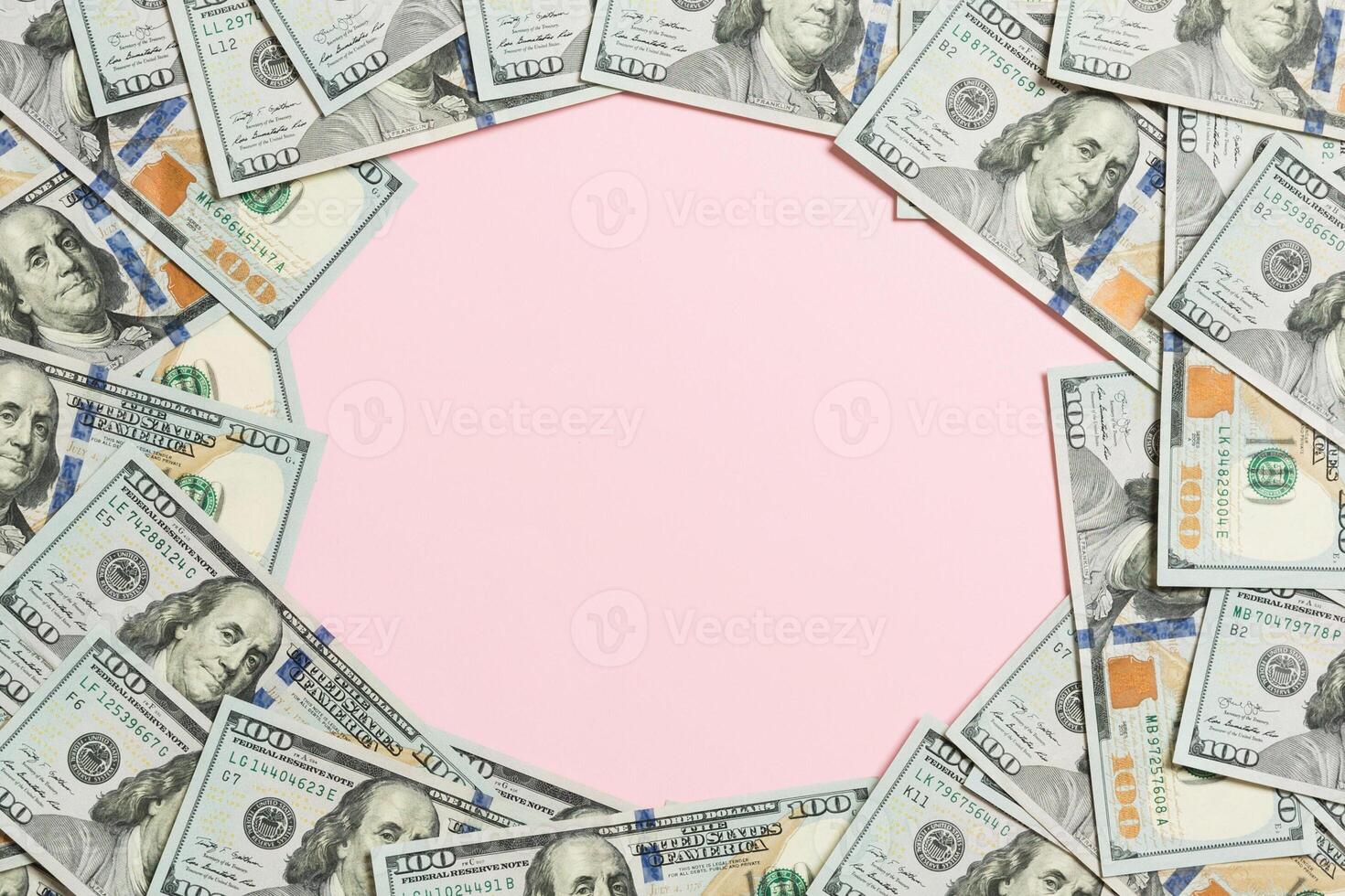 Frame of one hundred dollar bills with empty space for your design. Top view of business concept on pink background with copy space photo