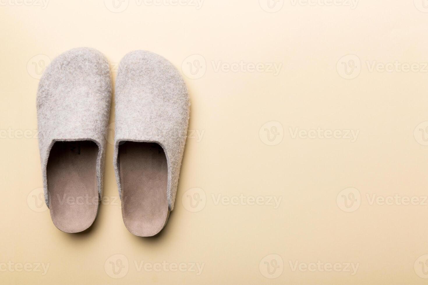 Warm winter women woolen slippers on colored background. Copy space for text photo