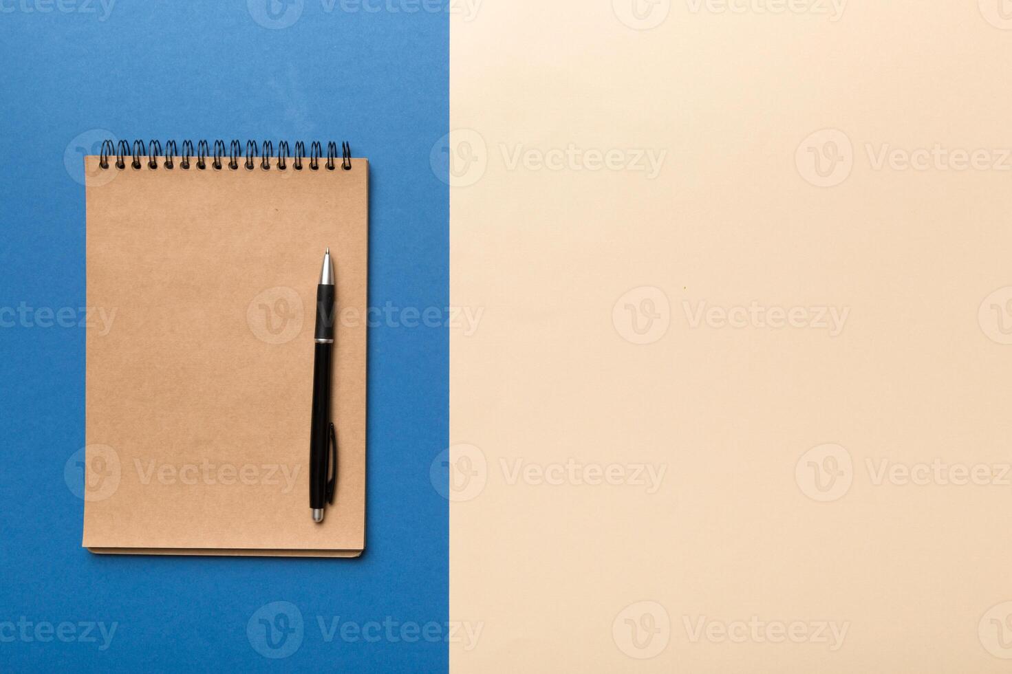 school brown notebook on a colored background, spiral craft notepad on a table Top view photo