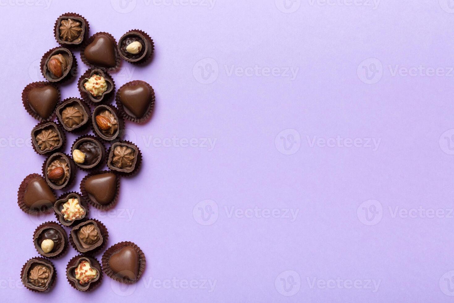 Different kinds of chocolates on colored table close-up. Top View and Flat Lay with copy space photo