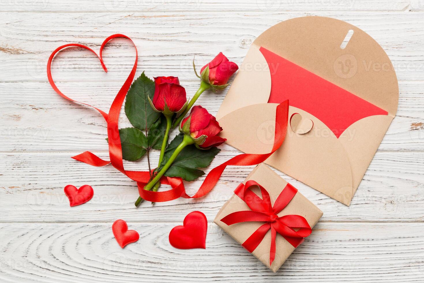 Valentine day composition with envelope, rose flower and red heart on table. Top view, flat lay, copy space Holiday concept photo