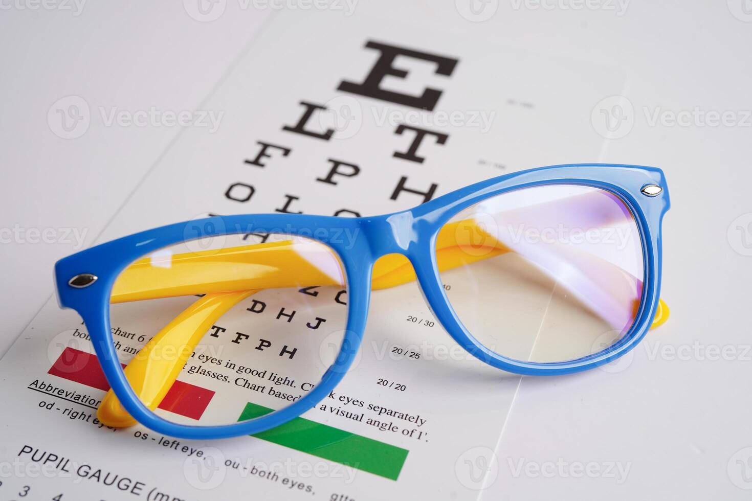 Glasses on eye exam chart to test eyesight accuracy of reading. photo