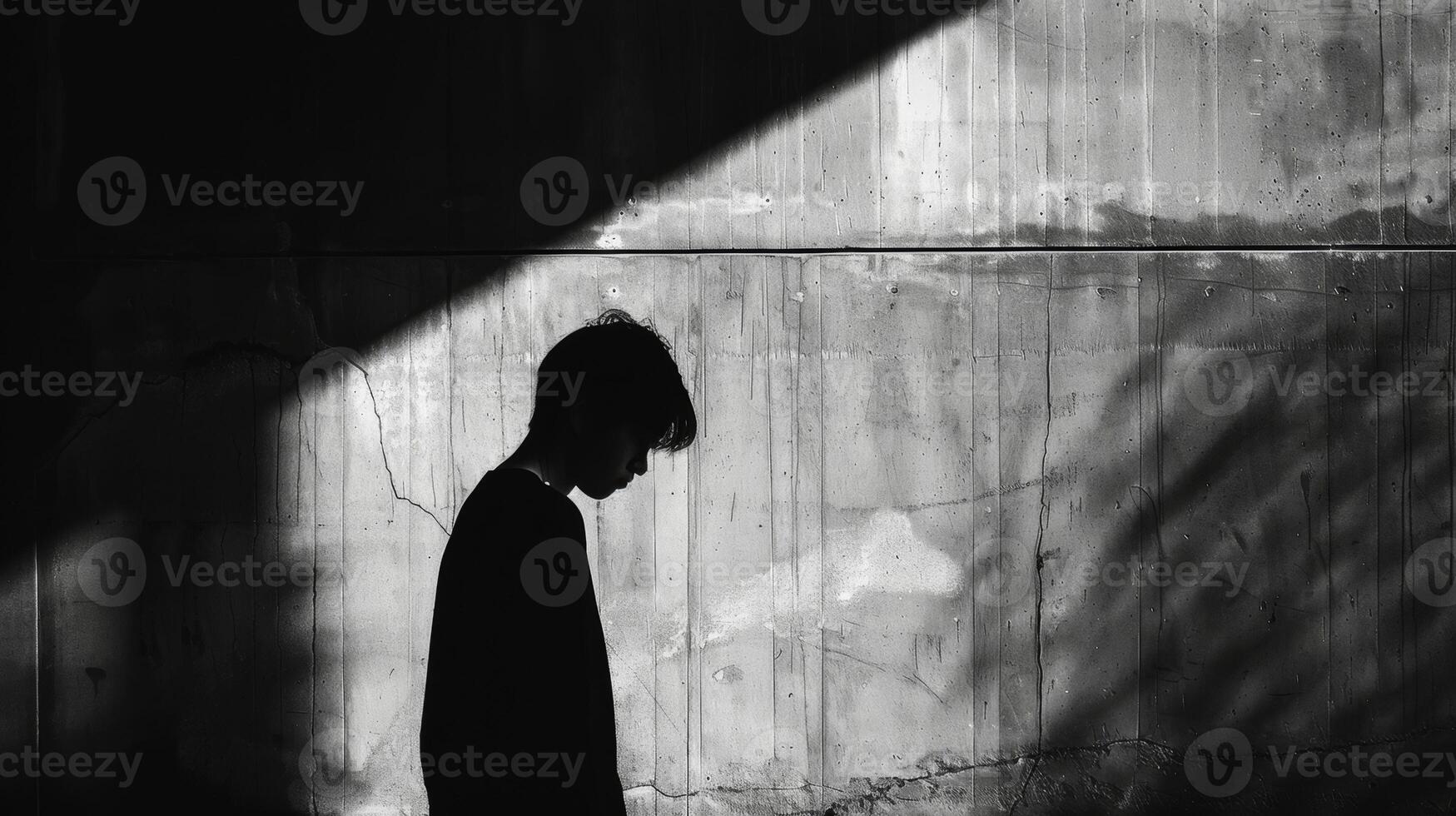 The mysterious shadow of a person leaning against a wall their identity and intentions unknown to the viewer. Black and white art. photo