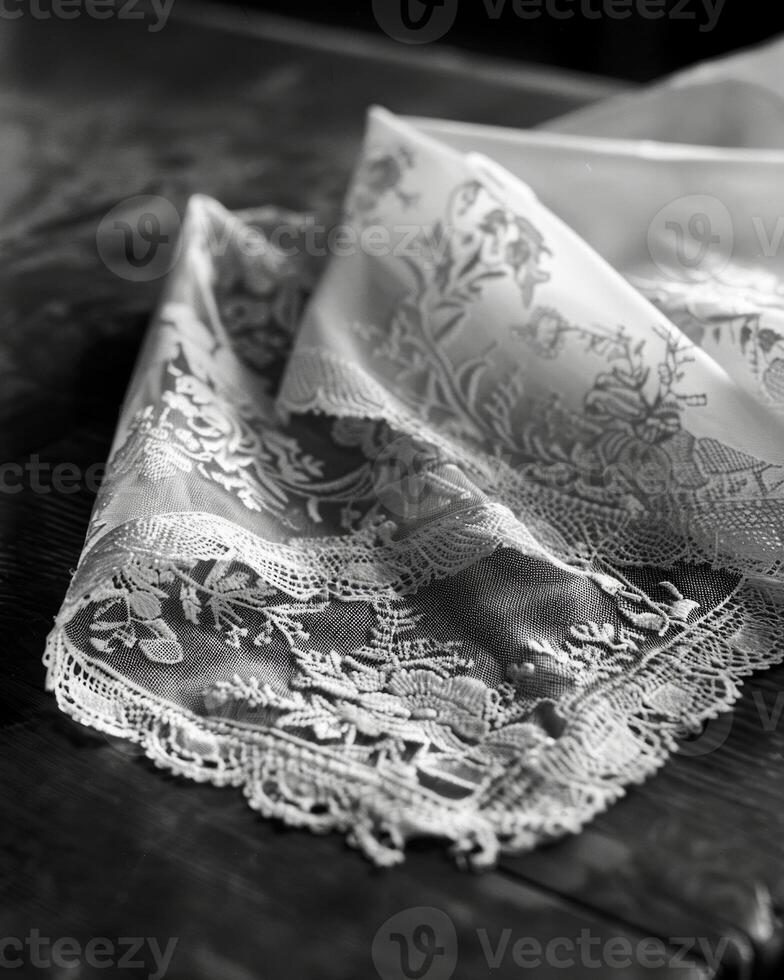 A handkerchief with delicate lace trim is carefully folded a reminder of the elegant accessories once commonplace in fashion. Black and white art. photo