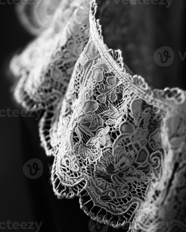 A closeup of a lace collart.showcases the delicate nature of the fabric a timeless detail that has adorned garments for centuries. Black and white art. photo