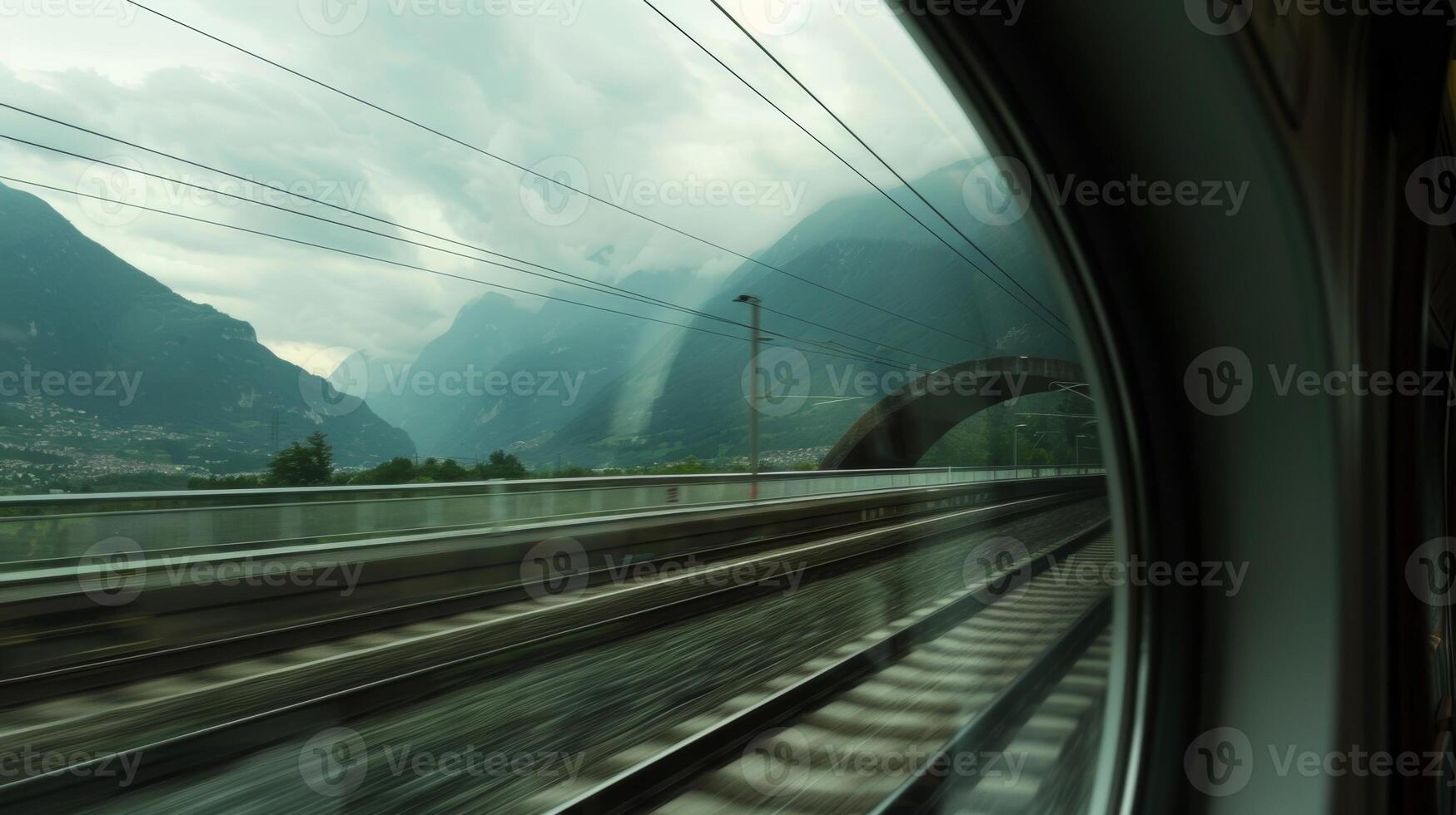Through the trains window a view of the mountain landscape can be seen as it emerges from the tunnel photo