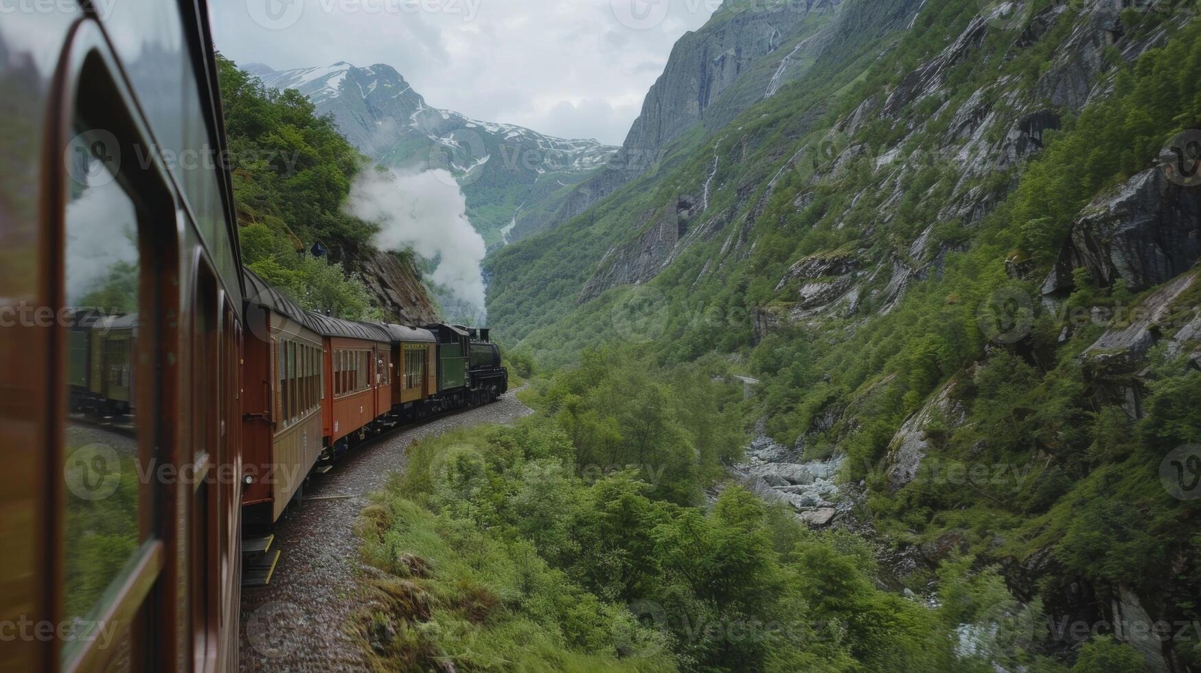 The train weaves its way through narrow valleys surrounded by towering green mountains photo