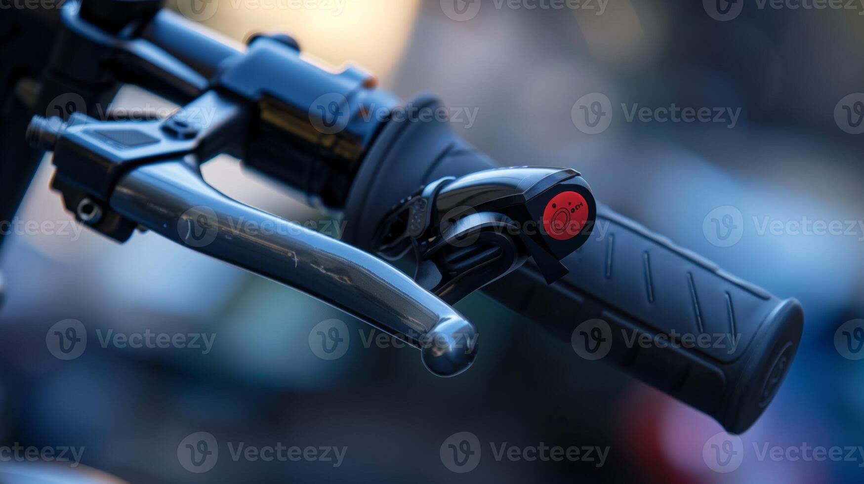 Closeup of an escooters brake lever with its smooth metallic finish and small red button for engaging the brake system photo