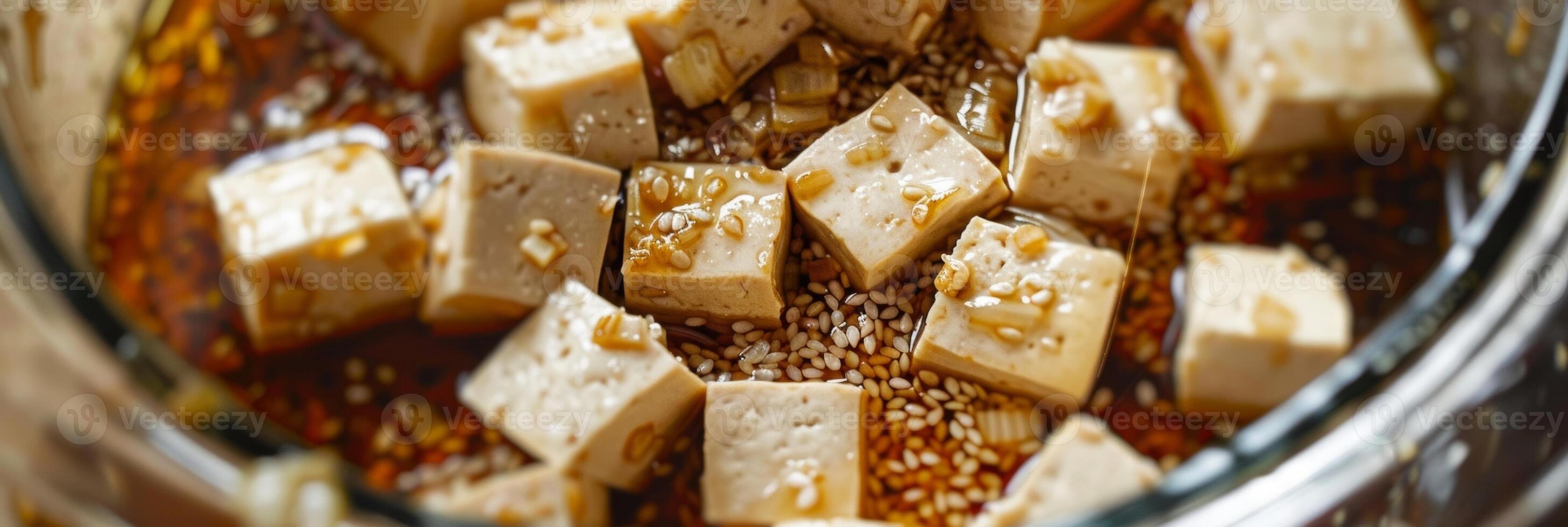 A closeup of sliced tofu being marinated in a mixture of soy sauce garlic and sesame oil photo