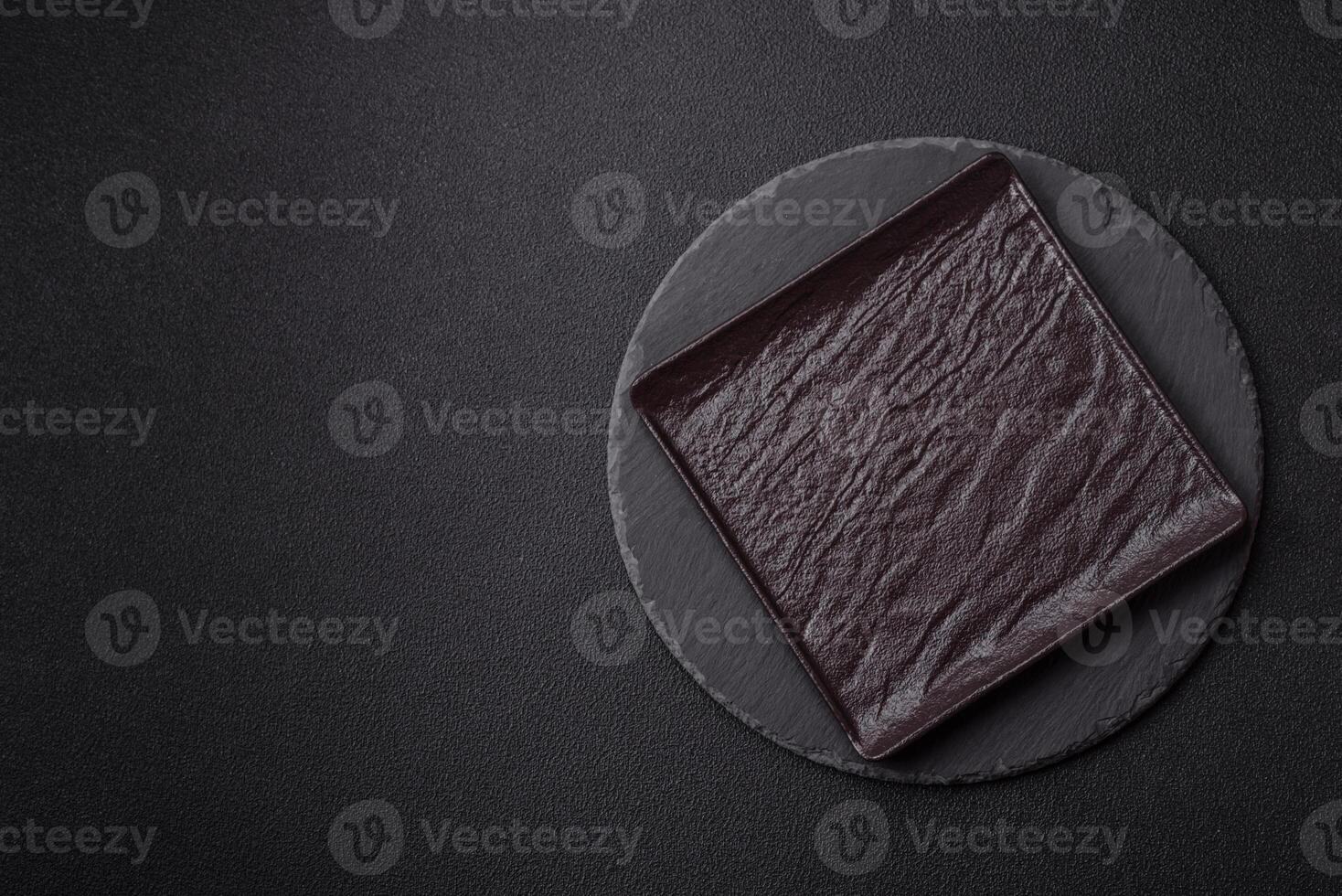 Empty round slate plate for template on the black background photo