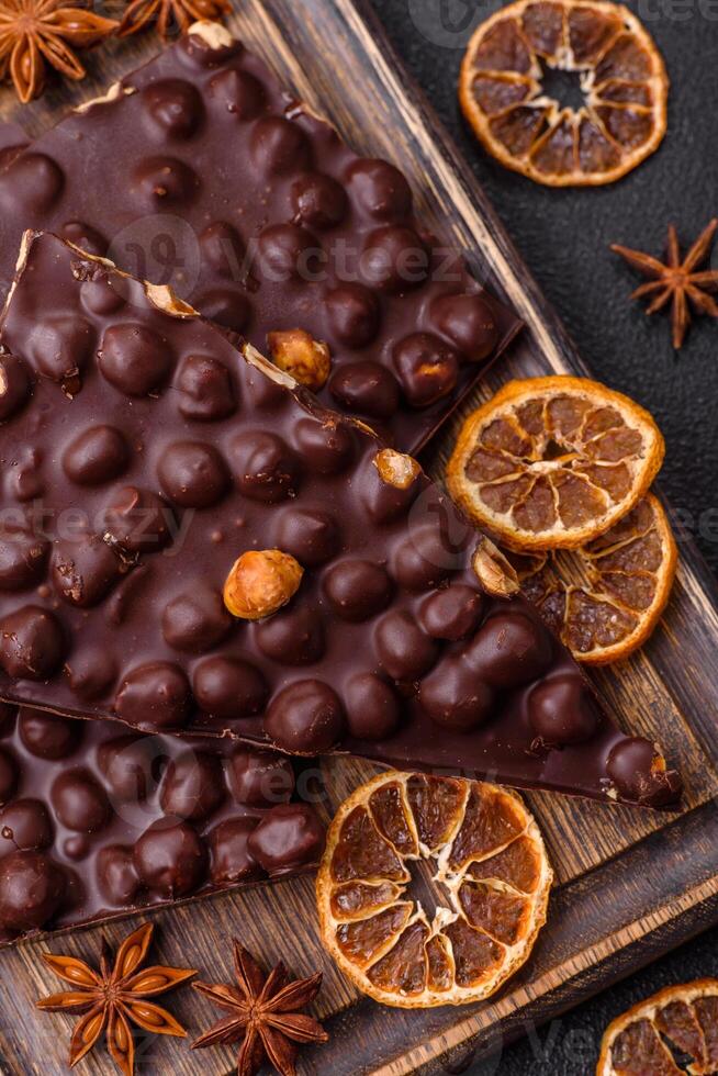 Black bitter chocolate with whole hazelnuts, candied fruits and mint photo