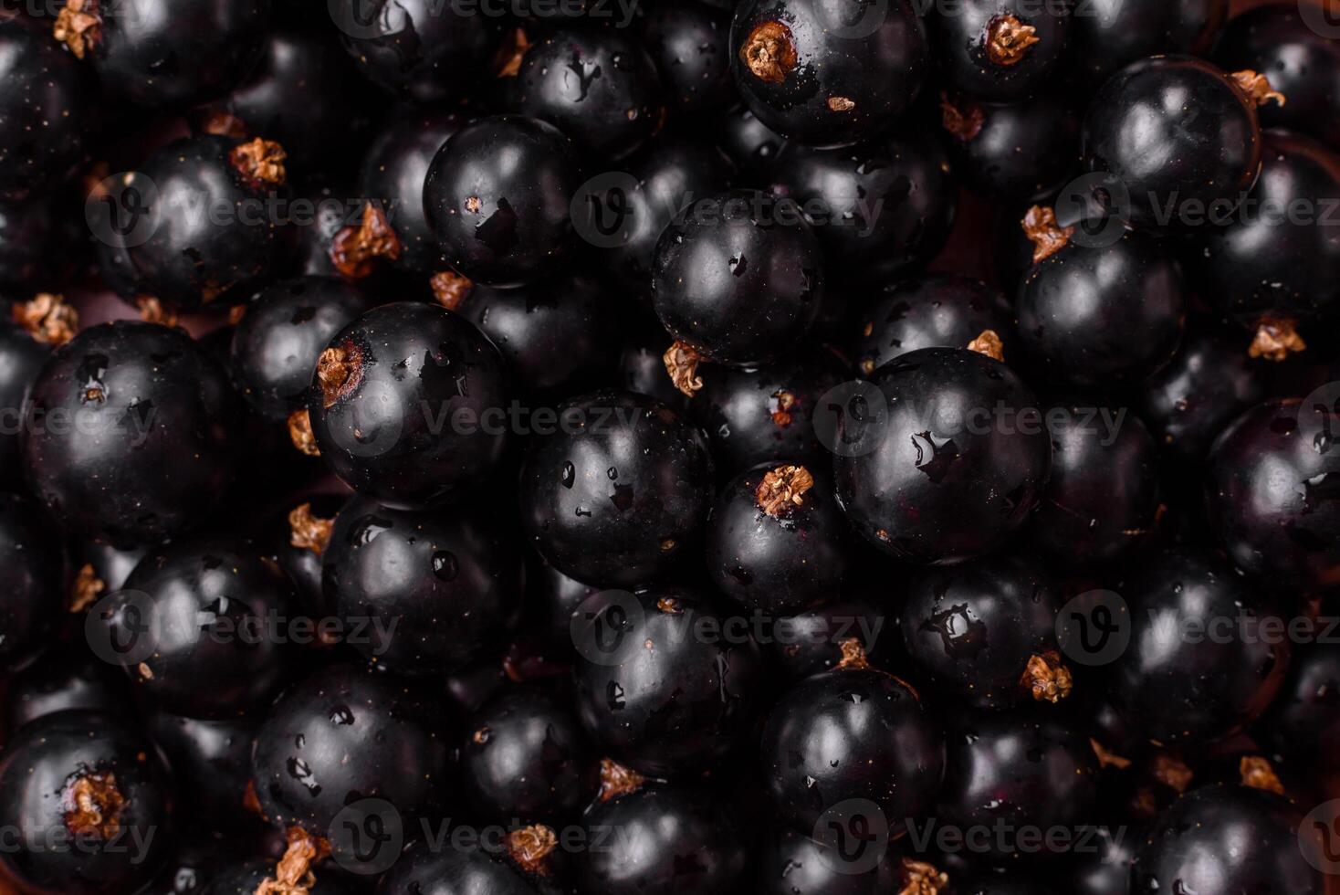 Ripe blackcurrant berries in droplets of water in a ceramic bowl photo
