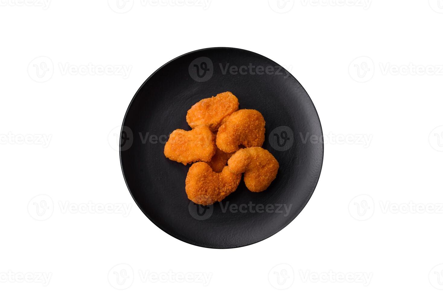 Delicious fresh crispy chicken nuggets on a dark concrete background photo