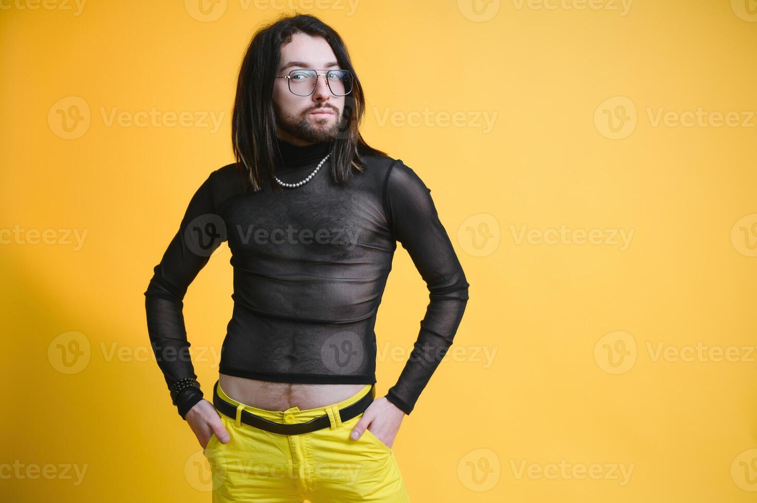 Young gay man is standing in the studio and posing for a camera. photo