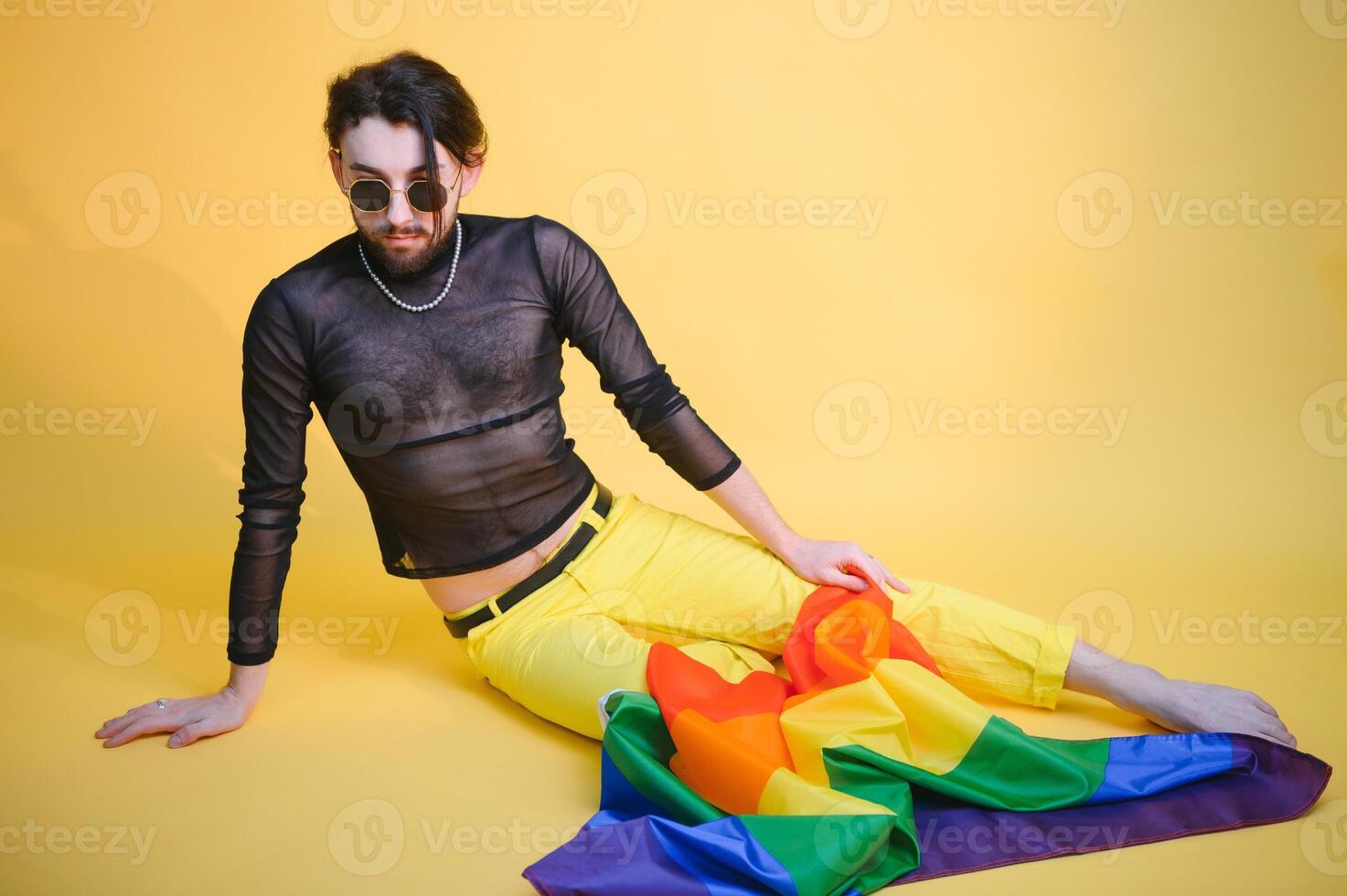 Young, handsome gay man on a colored background in the studio. LGBT concept. photo