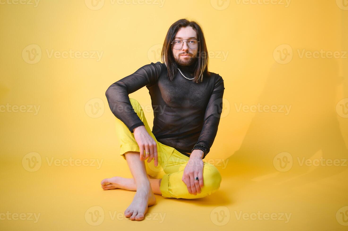 Young gay man is standing in the studio and posing for a camera. photo