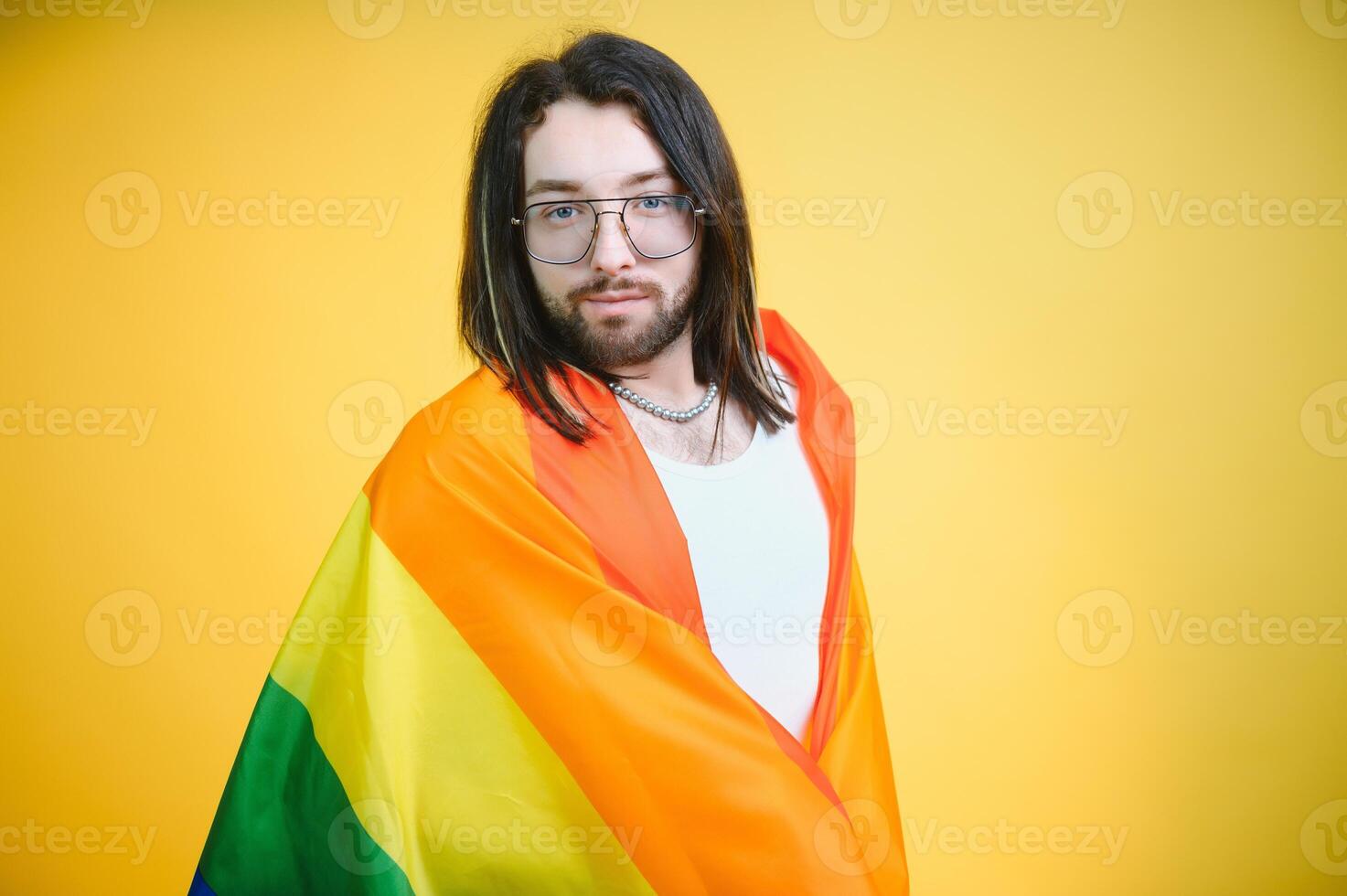 Gay man hold rainbow striped flag isolated on colored background studio portrait. People lifestyle fashion lgbtq concept photo