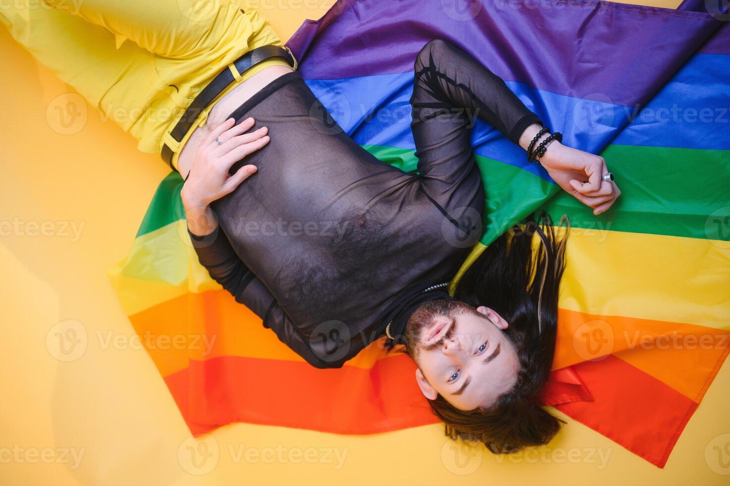 Happy gay man having fun holding rainbow flag symbol of LGBTQ community photo