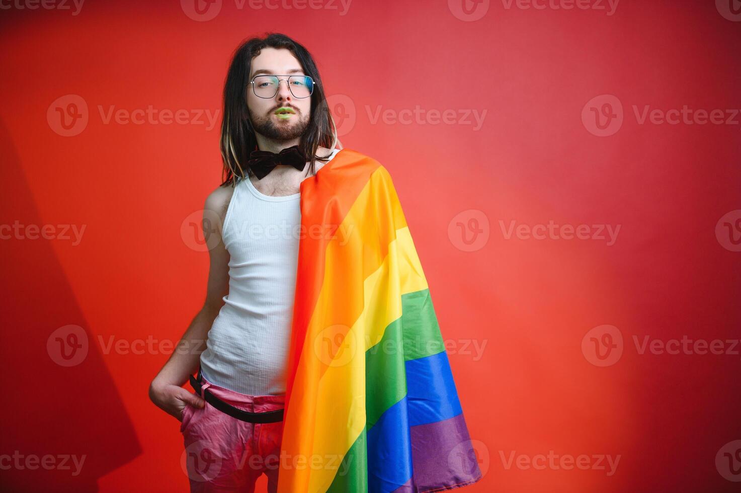 Happy gay man having fun holding rainbow flag symbol of LGBTQ community photo