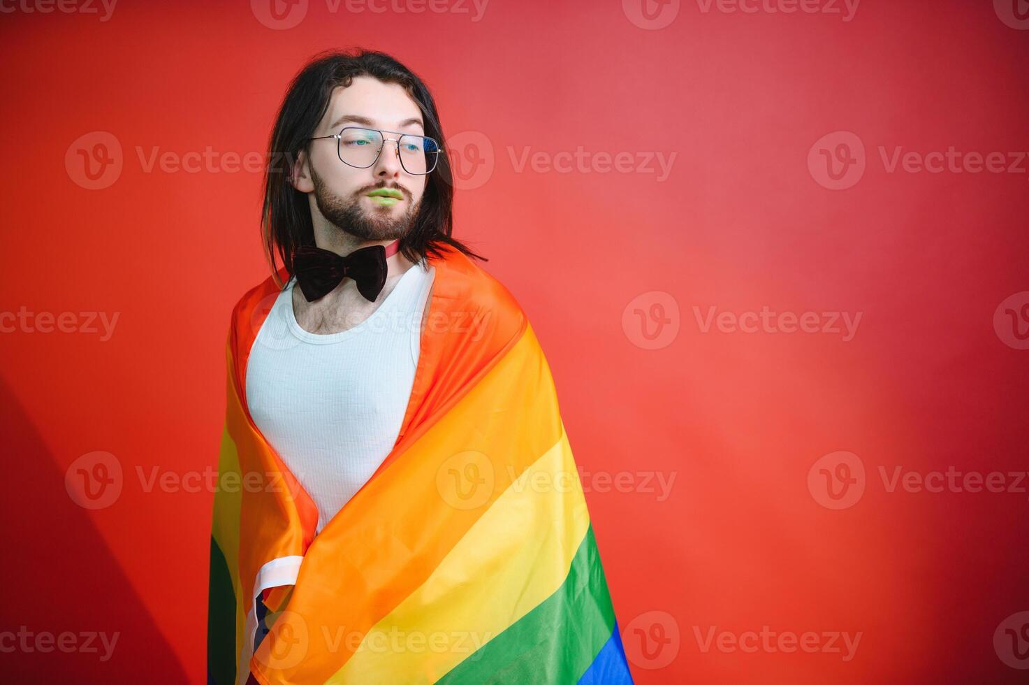 Gay man hold rainbow striped flag isolated on colored background studio portrait. People lifestyle fashion lgbtq concept photo