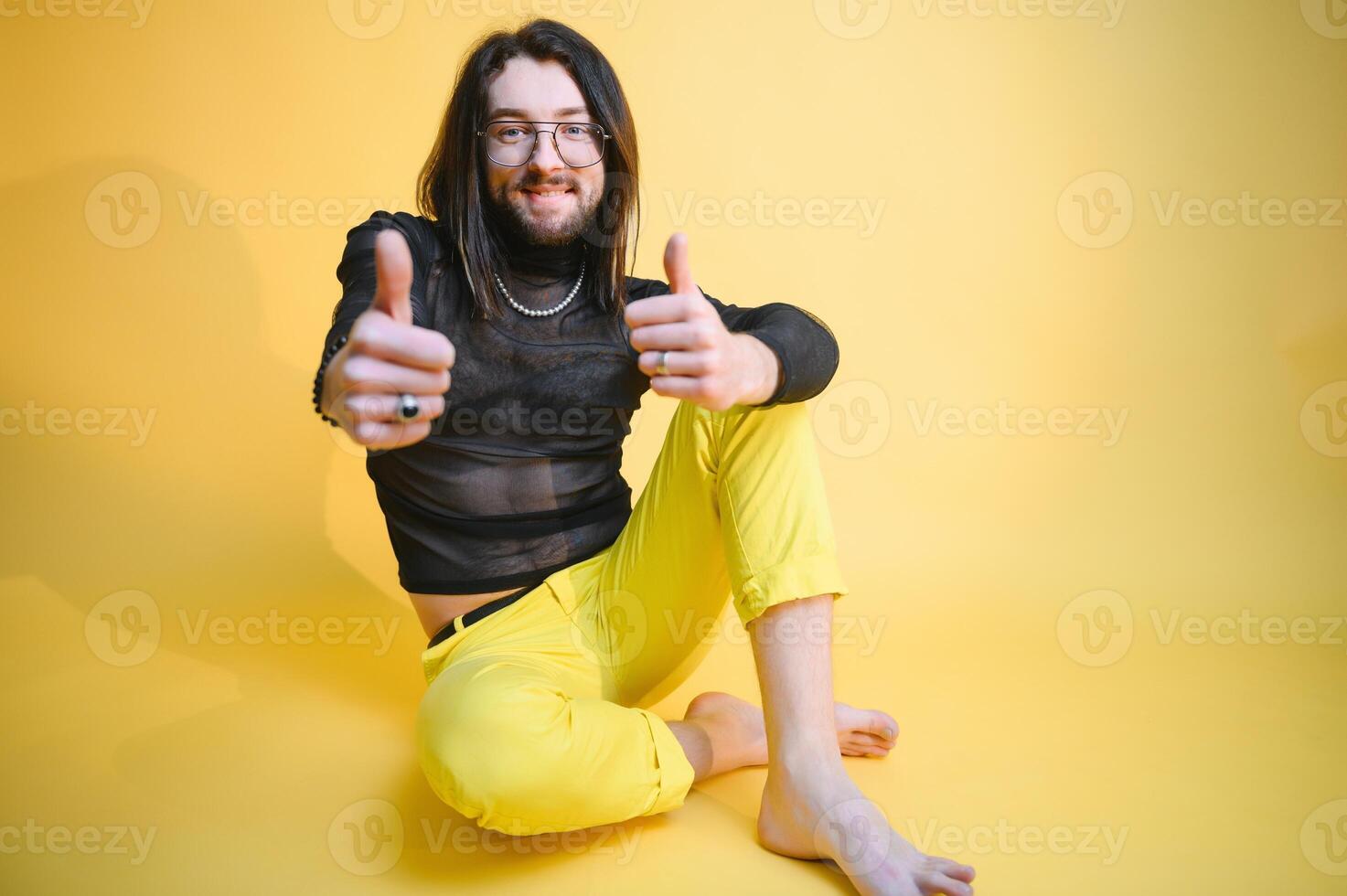 Young gay man is standing in the studio and posing for a camera. photo