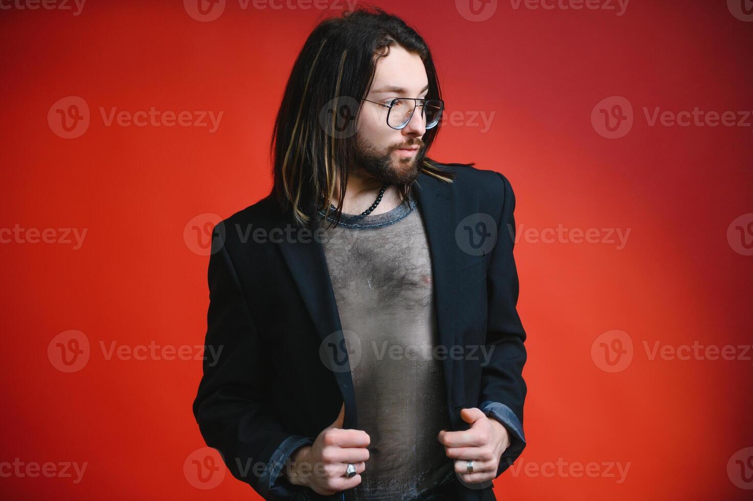 Young gay man is standing in the studio and posing for a camera. photo