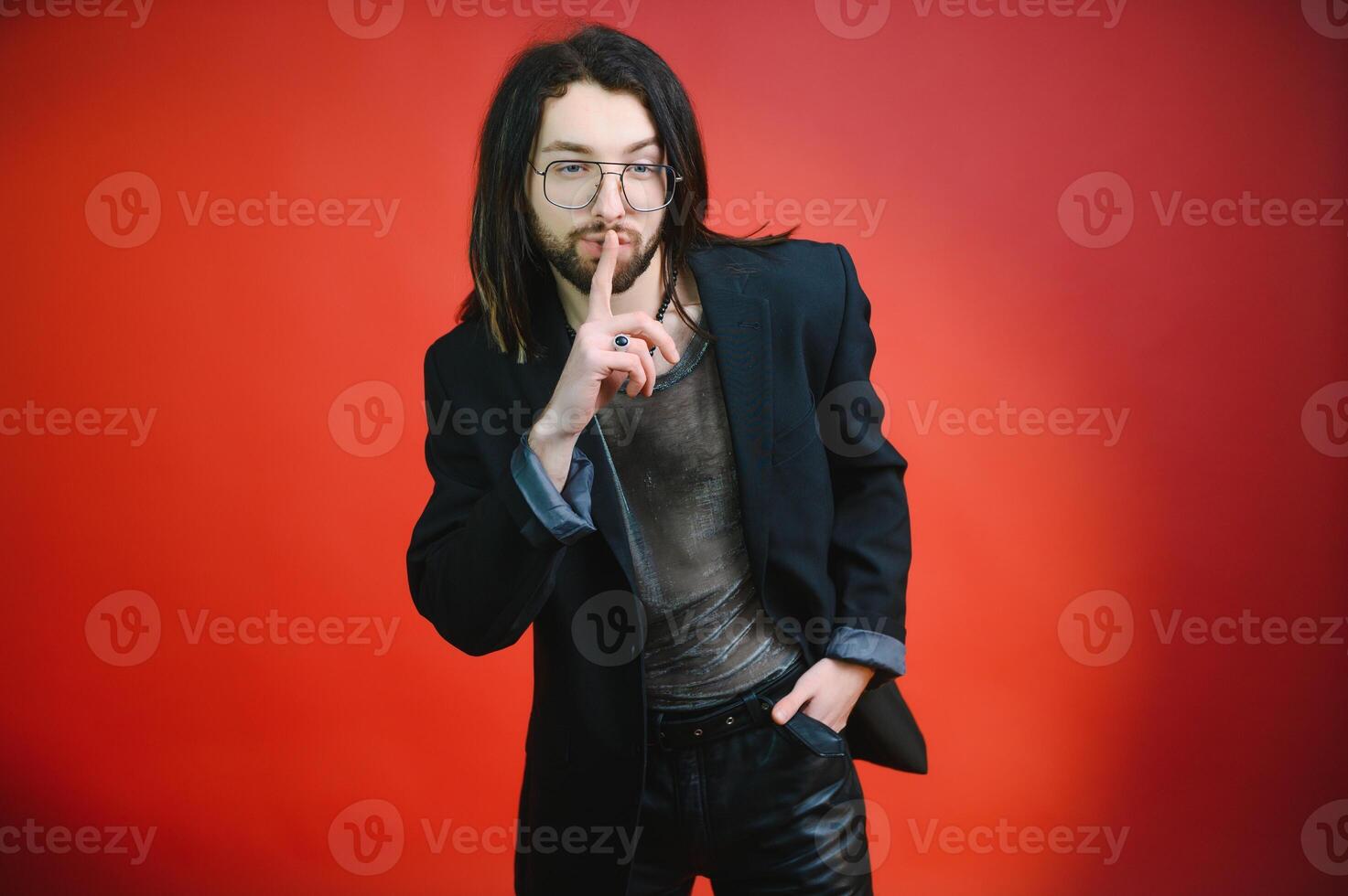 Young gay man is standing in the studio and posing for a camera. photo