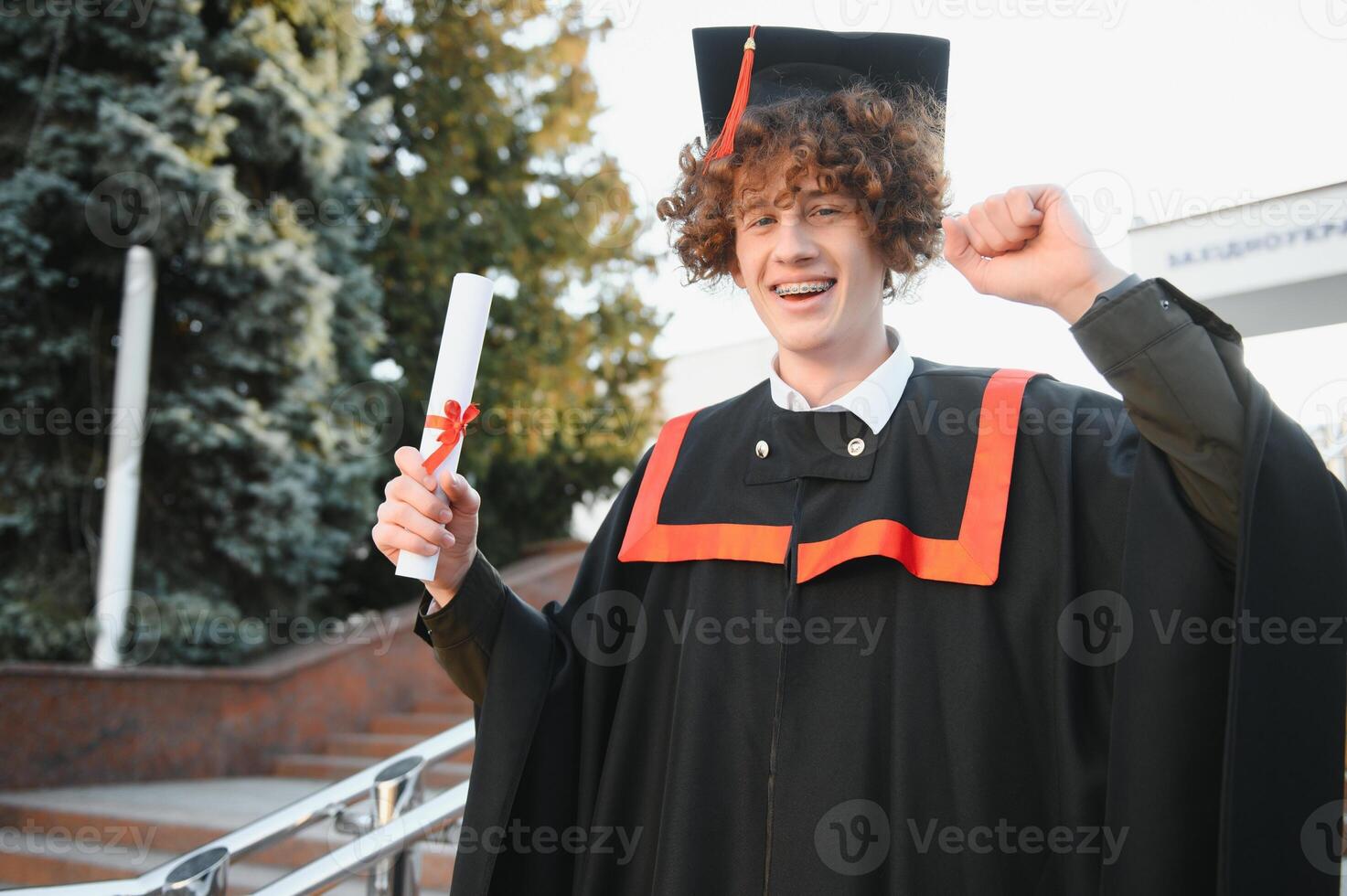Portrait of a confident and joyful young graduate with a diploma. Man is ready for the next step in his life. photo