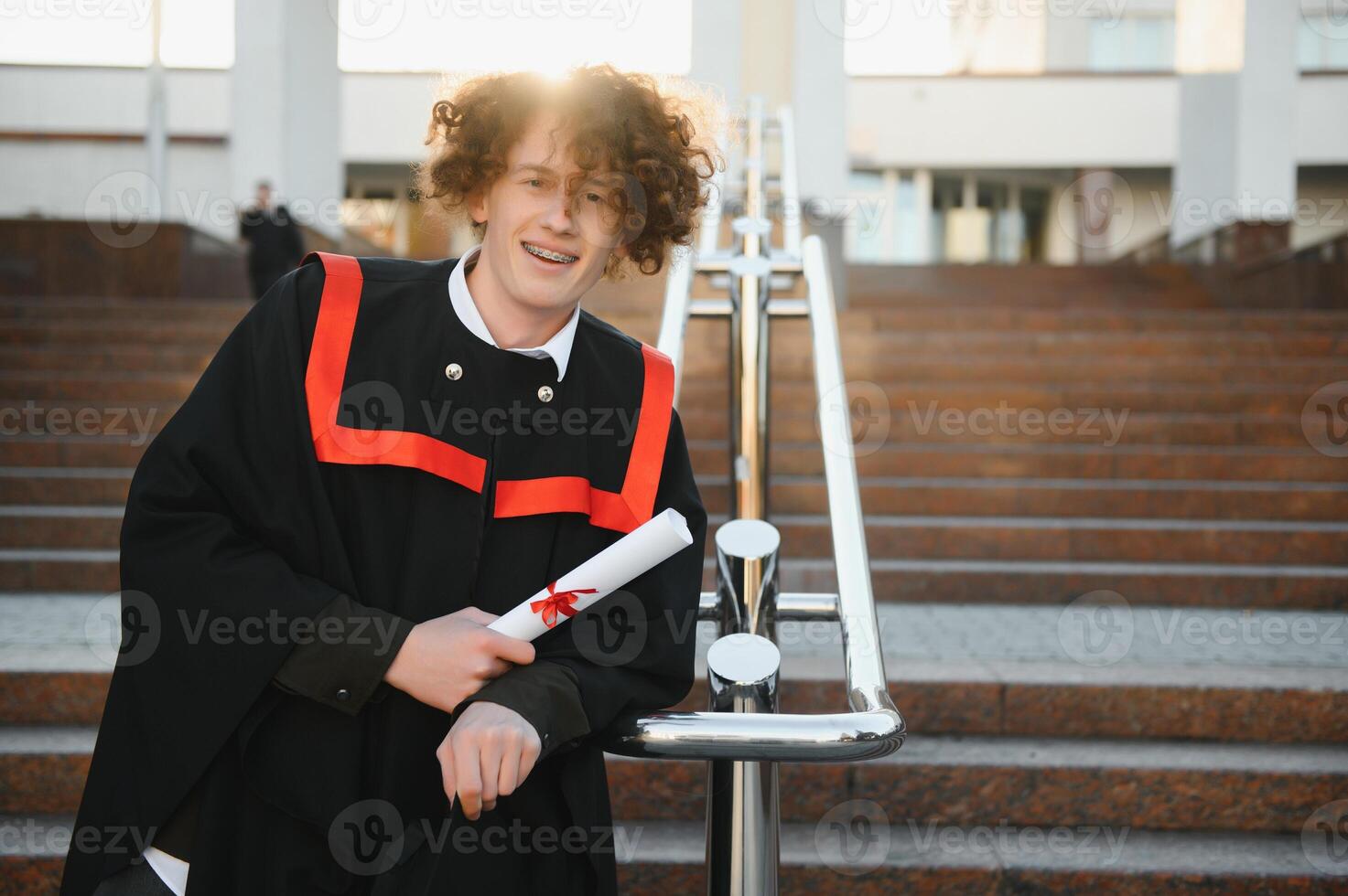 Portrait of a confident and joyful young graduate with a diploma. Man is ready for the next step in his life. photo
