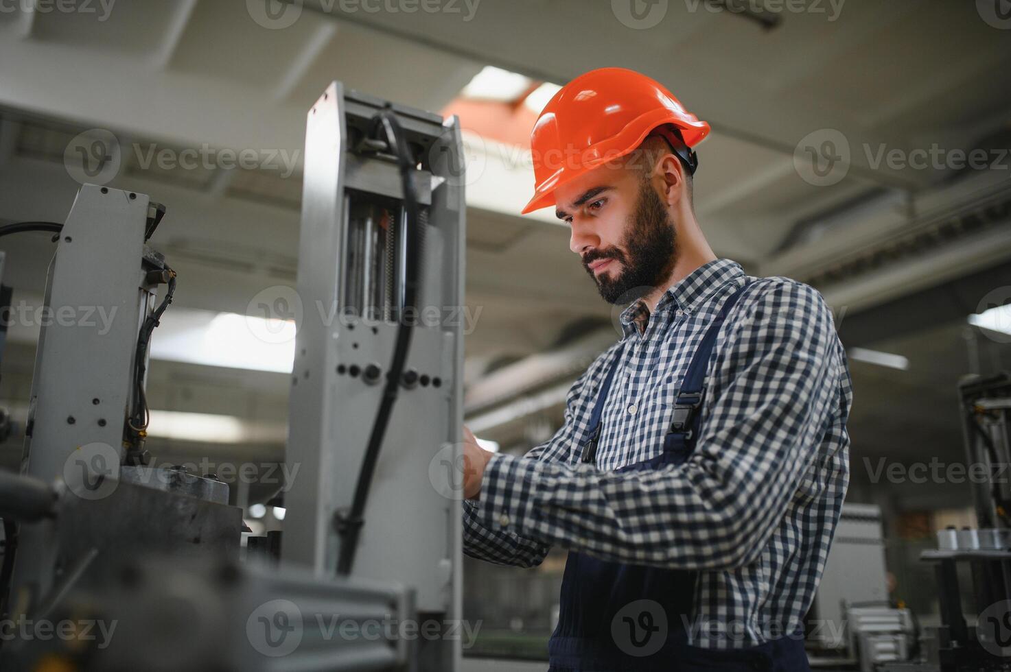 Portrait of factory worker in protective equipment in production hall. photo