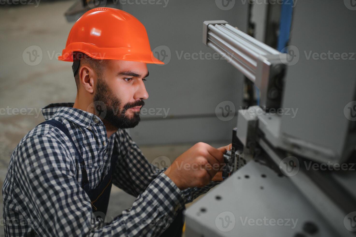 Portrait of industrial engineer. Factory worker with hard hat standing in factory. photo