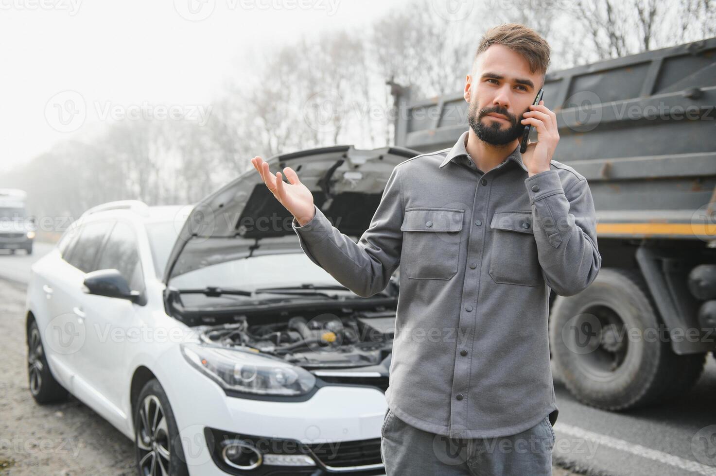 Man use a cellphone call garage in front of the open hood of a broken car on the road in the forest. Car breakdown concept. photo