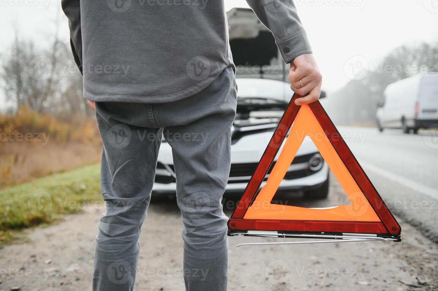 Sad man on the road next to the broken car photo