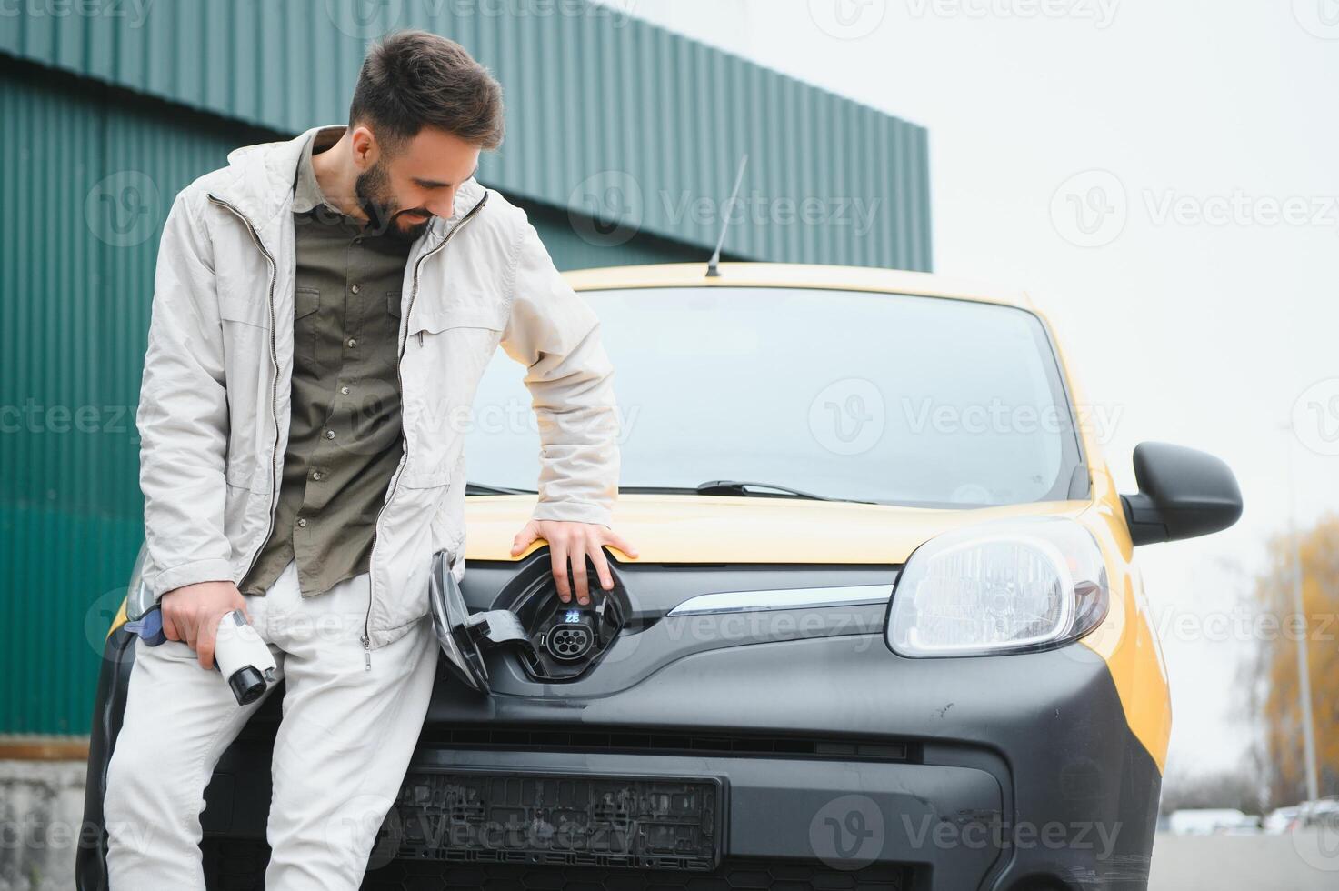 Man holding power connector for electric car photo