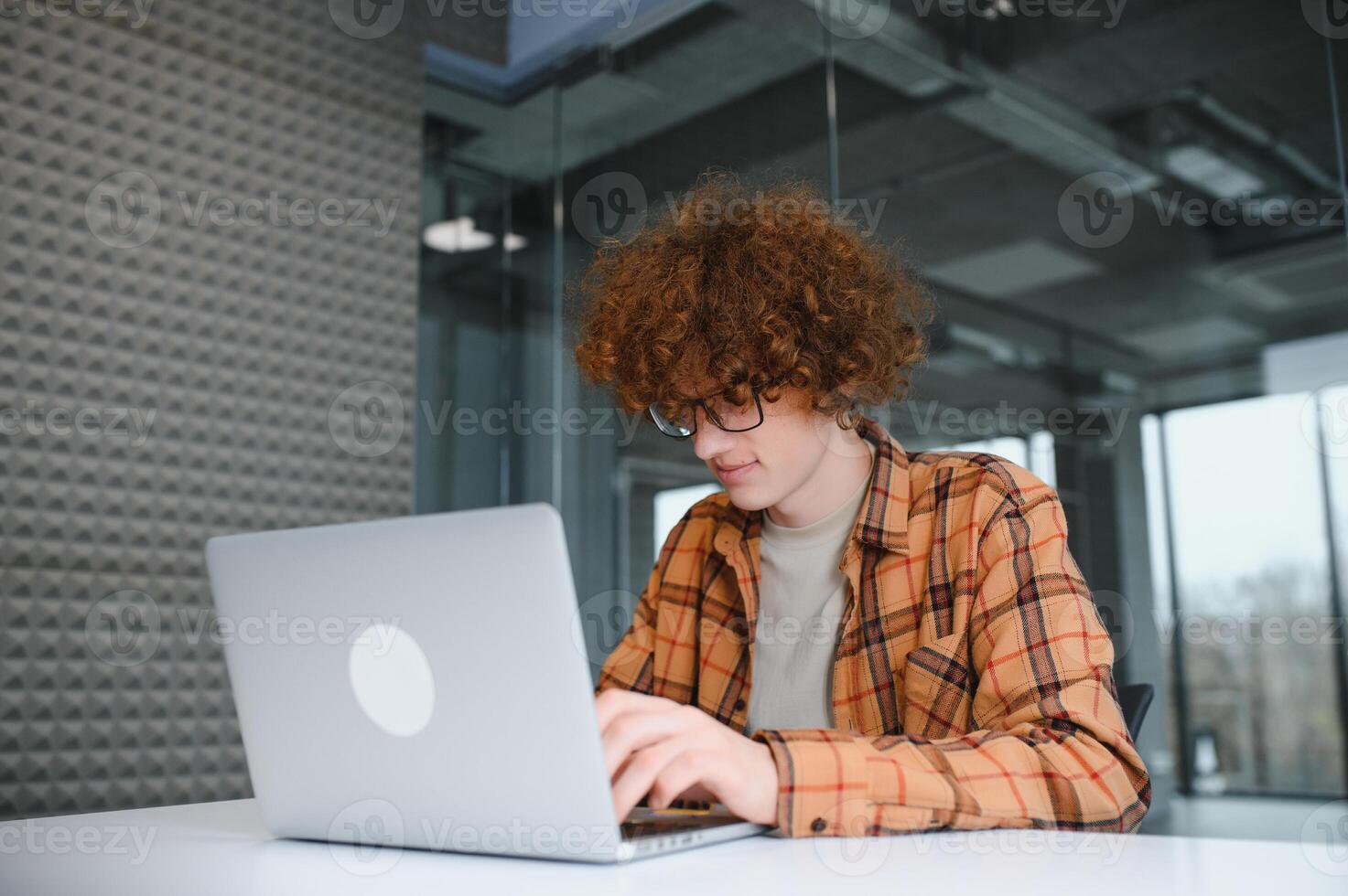 Cheerful male freelancer browsing funny content while networking in social media using netbook technology in street cafe, happy hipster guy enjoying free time for online blogging via laptop photo