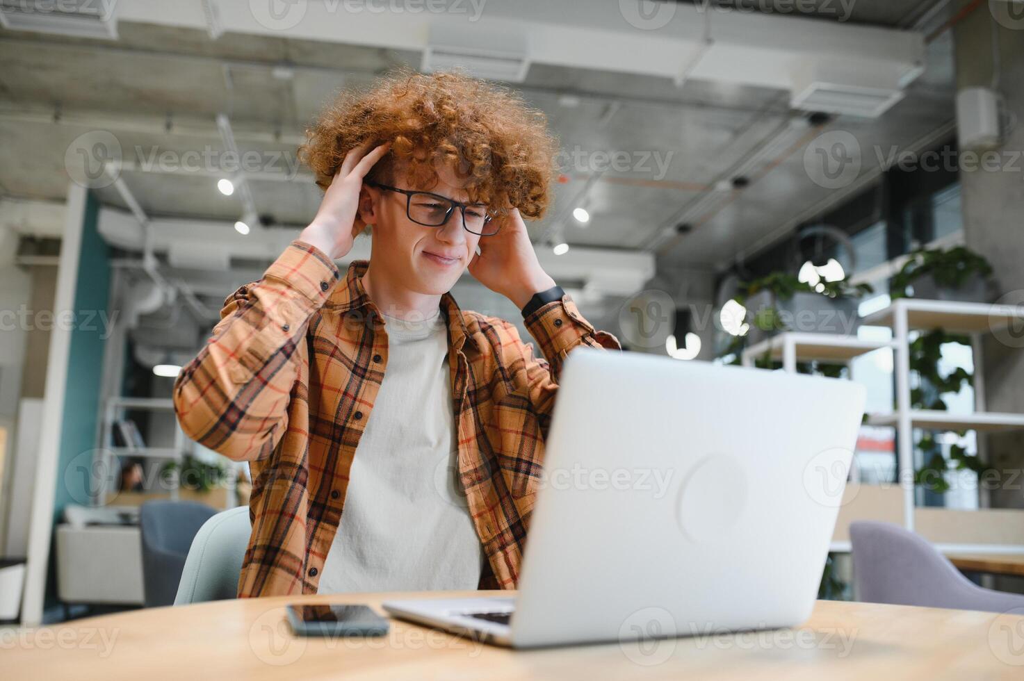 male programmer wear spectacles for eyes protection while working on freelance via laptop computer,clever student watching tutorial on netbook. photo