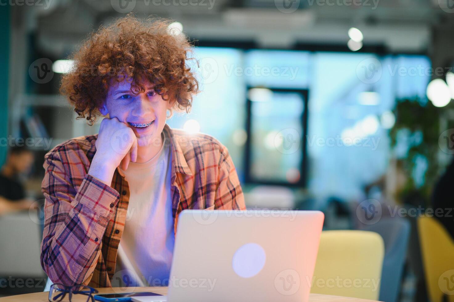 Cheerful male freelancer browsing funny content while networking in social media using netbook technology in street cafe, happy hipster guy enjoying free time for online blogging via laptop photo