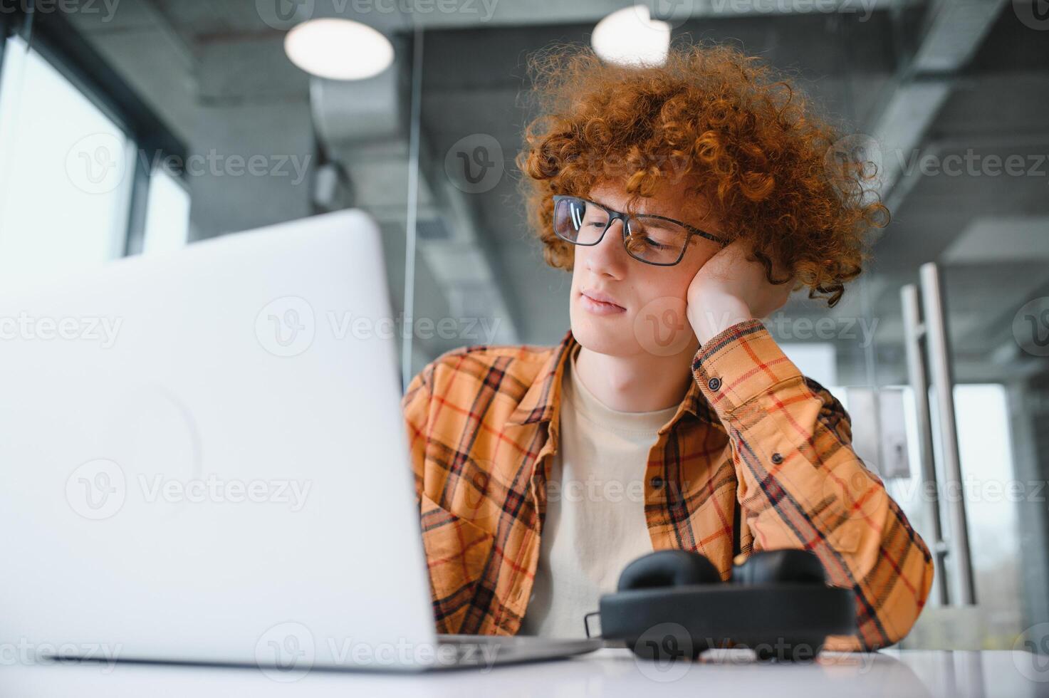male programmer wear spectacles for eyes protection while working on freelance via laptop computer,clever student watching tutorial on netbook. photo
