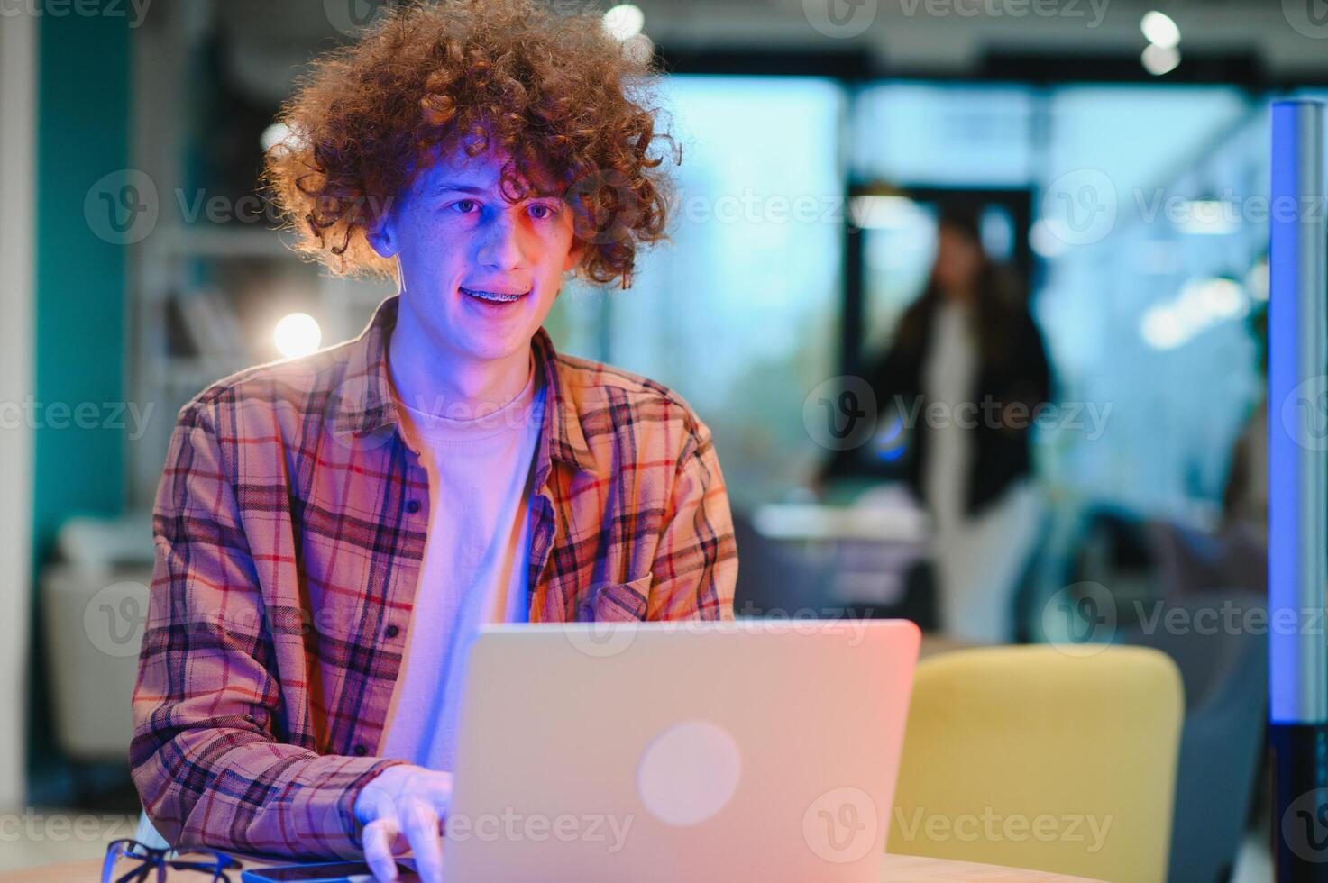 Cheerful male freelancer browsing funny content while networking in social media using netbook technology in street cafe, happy hipster guy enjoying free time for online blogging via laptop photo