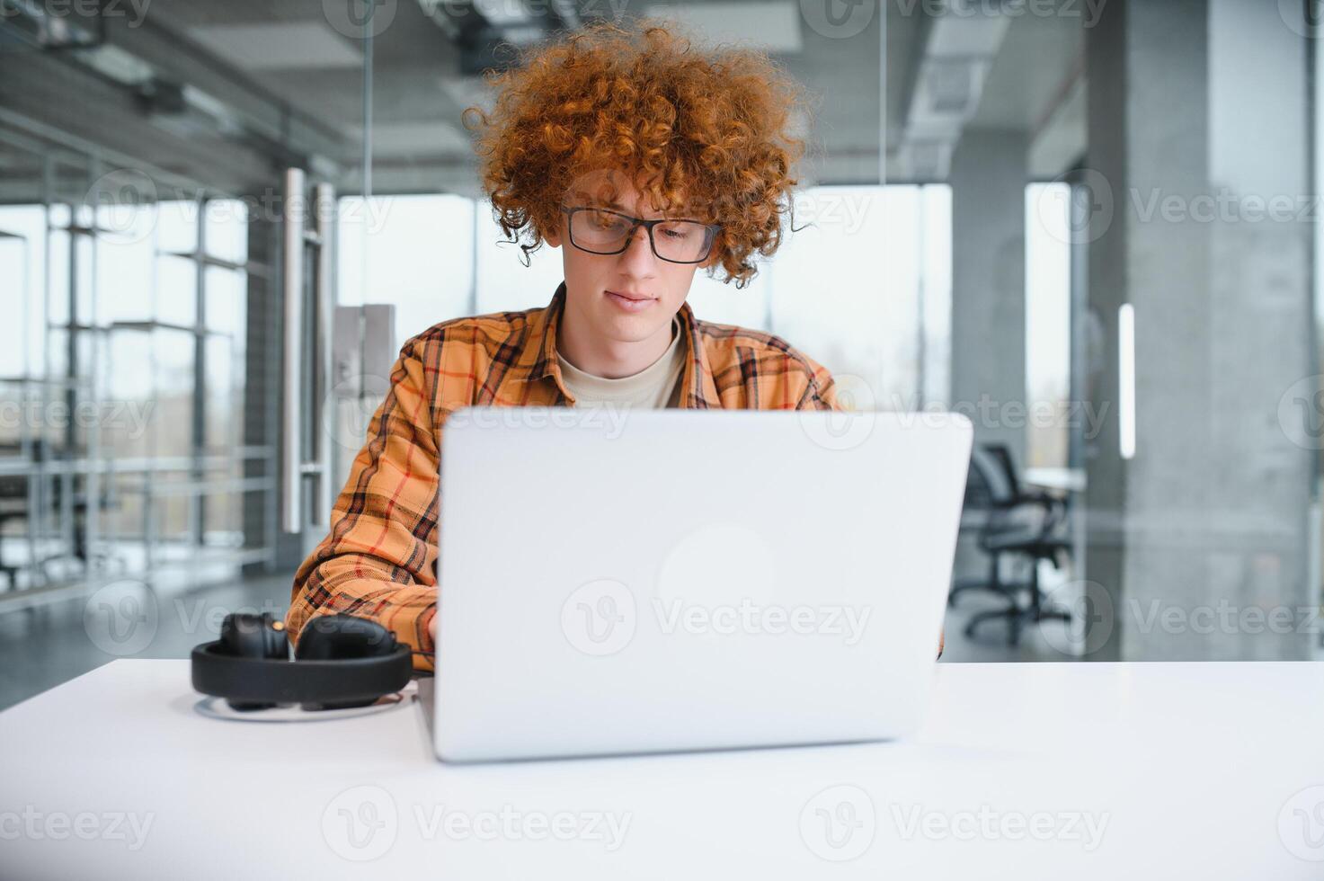 male programmer wear spectacles for eyes protection while working on freelance via laptop computer,clever student watching tutorial on netbook. photo