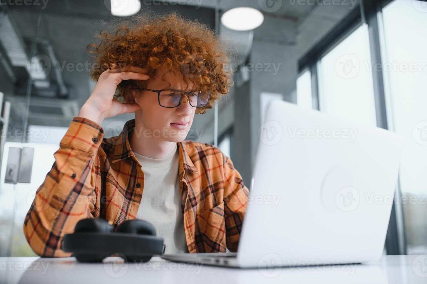 male programmer wear spectacles for eyes protection while working on freelance via laptop computer,clever student watching tutorial on netbook. photo
