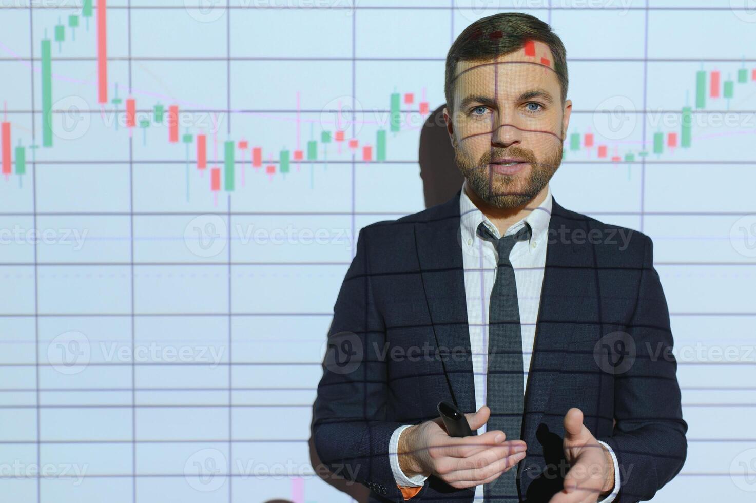 Man is standing near projector and showing graphs and business graphs. photo