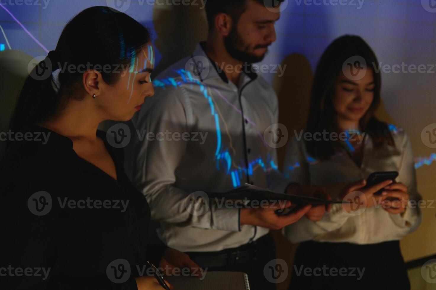 Group of business people working at modern office.Technical price graph, red and blue candlestick chart and stock trading computer screen background. Double exposure. Traders analyzing data photo