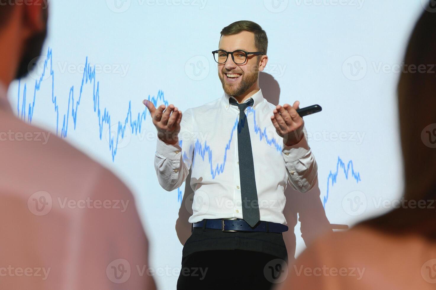 Happy speaker giving presentation in conference hall photo