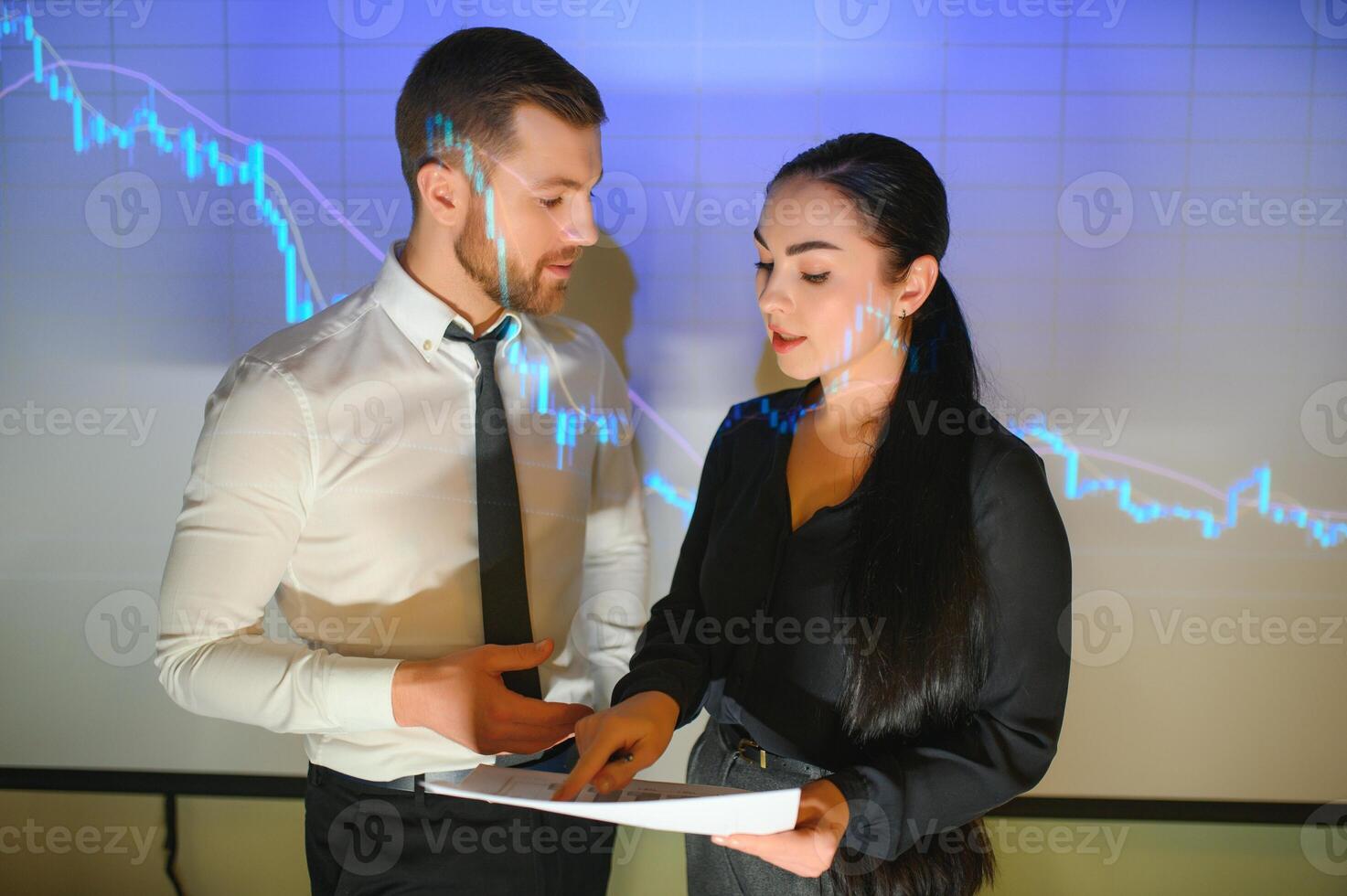 Trading teaching. Male leader talking to employees, showing the plan on the projector in office of stock exchange company. photo